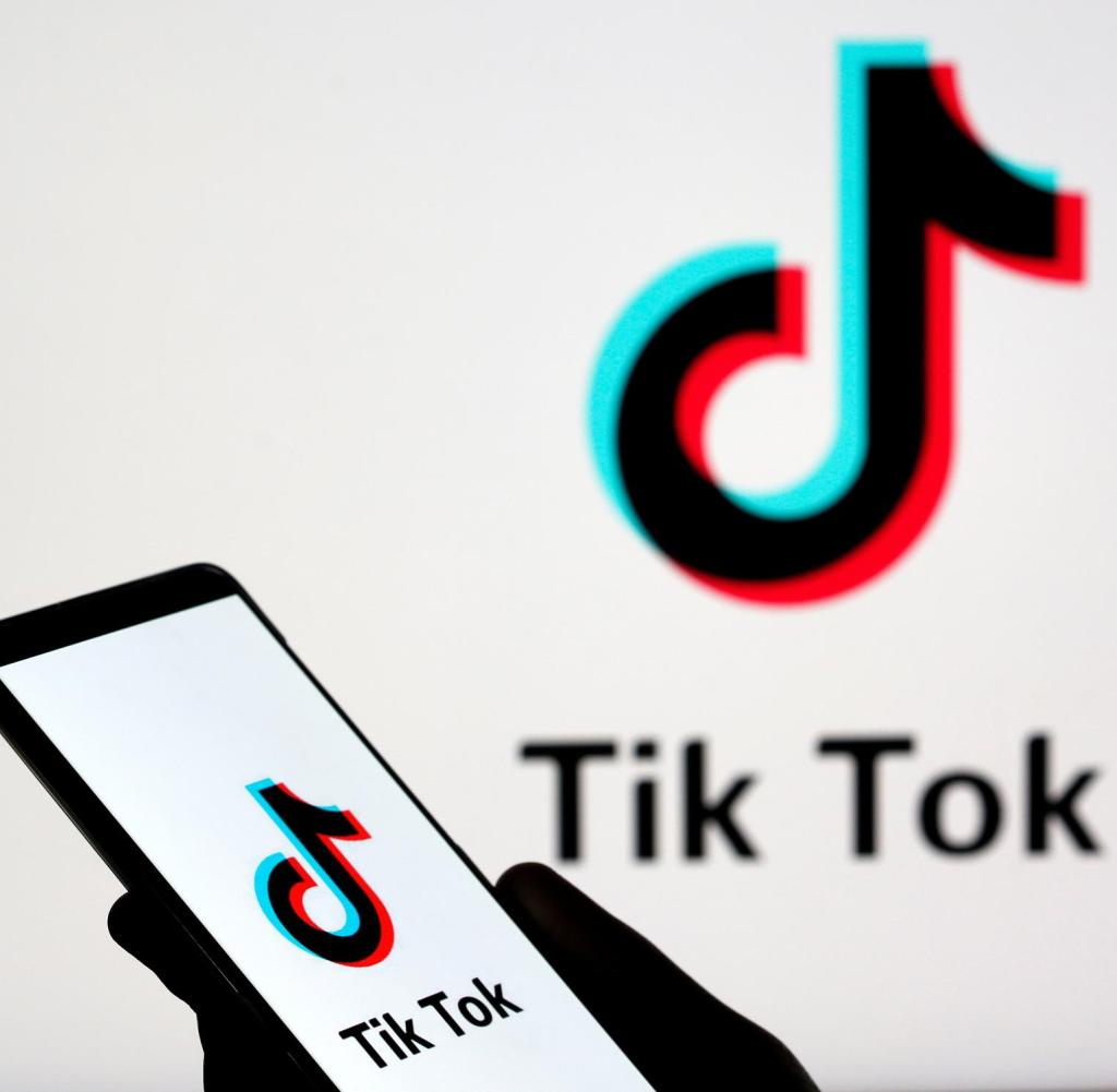 Die Person hält ein Smartphone mit dem Tik Tok-Logo in dieser Fotoabbildung